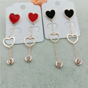 Détail de boucles d'oreilles cœur en acier inoxydable avec pendentifs rouges et noirs
