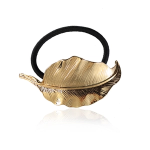 Elegant gold metal leaf hair tie with black elastic band on white background