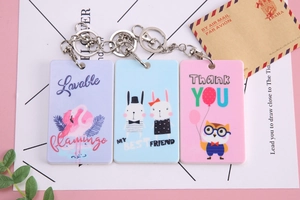 Detailed view of three cartoon card holders with metal keychains and animal prints