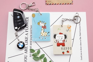 Close-up of cute cartoon giraffe and elephant acrylic keychains with metal ring attachments