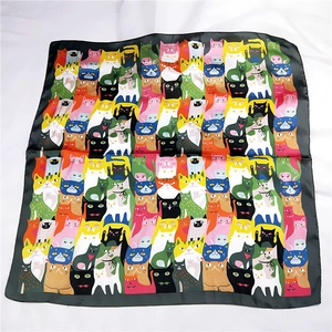 Close-up of colorful cartoon cat patterns on a satin silk scarf with black borders