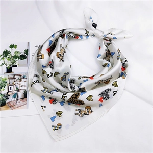 Detailed view of square silk scarf with zebra and heart print on soft white background