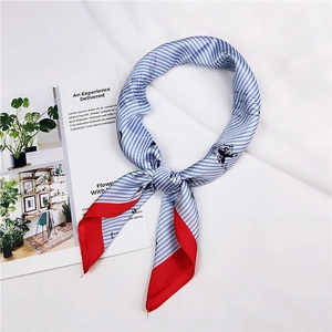 Detail of blue and white striped silk scarf with red edges and elegant handwriting print
