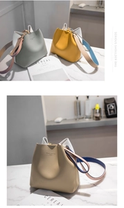 Detail of color-block bucket bag showing matte leather texture and gold hardware detail