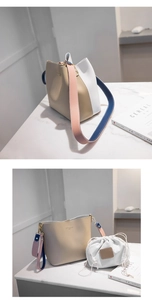 Macro detail of color-block bucket bag with canvas insert and wide leather shoulder strap