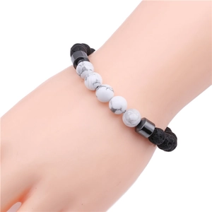 Close-up of beaded stretch bracelet with white turquoise and black lava stones on wrist