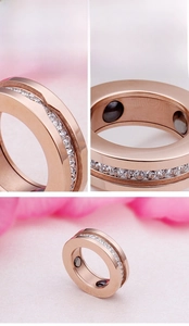 Detail of rose gold magnetic therapy ring with white zircons and inner black magnets