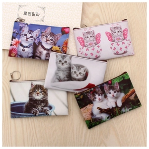 Detail showing five cat pattern coin purses with metal zippers and key rings on wood