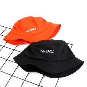 Close-up of black and orange cotton bucket hats with white NO-CHILL embroidery on wire mesh