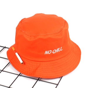 Close-up of NO CHILL white embroidery on a bright orange cotton bucket hat