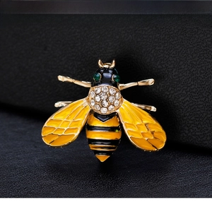 Close-up of a bee brooch with yellow enamel wings and sparkling crystal details