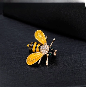 Macro shot of bee brooch with yellow enamel, gold plating and sparkling crystal accents