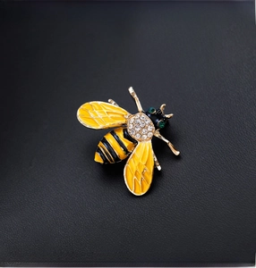 Detailed macro view of bee brooch with yellow enamel and crystal-studded wings