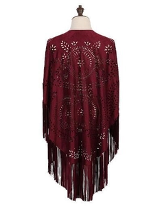 Close-up of wine red faux suede poncho featuring intricate laser-cut patterns and long fringe