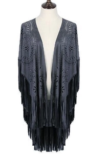 Detail of dark grey faux suede poncho featuring laser-cut patterns and long fringe tassels