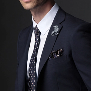 Close-up of a silver lion brooch with diamonds on a premium men's suit lapel