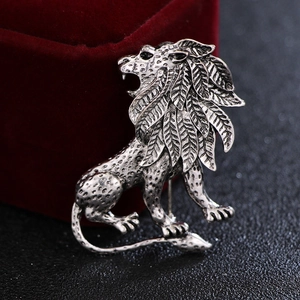 Macro shot of retro silver lion brooch featuring detailed leaf-pattern mane texture