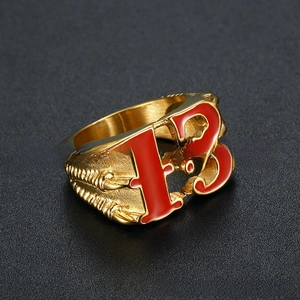 Vue macro de la bague griffe de dragon dorée avec le numéro 13 rouge détaillé