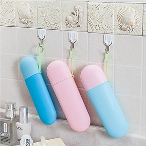 Portable candy-colored toothbrush storage cases hanging on bathroom wall hooks