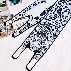 Detail showing blue silk scarf with cartoon leopard pattern and black animal print texture