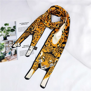 Detail of cartoon leopard print scarf showing 100% polyester label and magazine backdrop