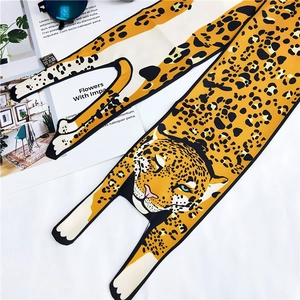 Detail showing yellow leopard print silk scarf with stylized animal head and accessories