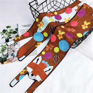 Detail of cartoon fox and gingerbread man pattern on a brown silk twilly scarf over a basket