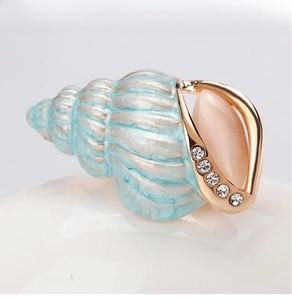Detail view of light blue enamel conch brooch with cat eye stone and sparkling crystals