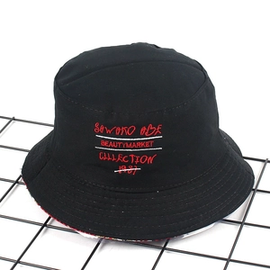 Detailed embroidery on a black cotton bucket hat featuring red and white street style text