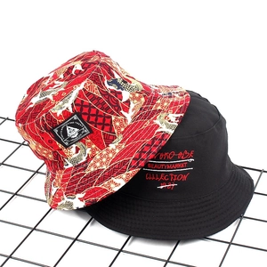 Detail of red koi fish print bucket hat and black cotton hat with embroidery