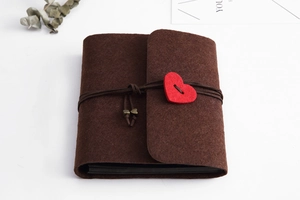 Close-up of brown felt DIY scrapbook with leather cord and red heart detail