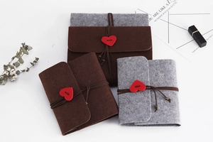 Detailed view of DIY felt photo albums with heart buttons and vintage leather cords