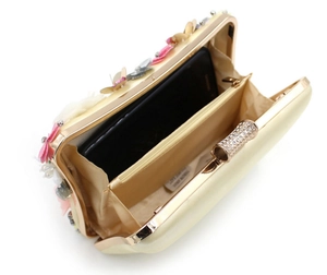 Detailed interior of a floral evening clutch bag showing beige lining and phone capacity