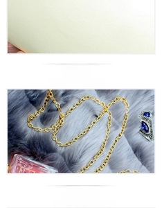 Detail of gold electroplated chain and zipper compartment in floral evening bag