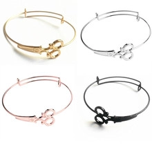 Detail view of hollow scissors charm bracelets in gold, silver, rose gold, and black finishes
