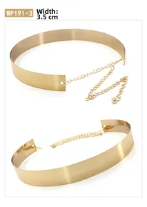 Detail of 3.5cm wide polished gold metal waist belt with smooth mirror finish and chain
