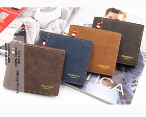 Primer plano de cuatro carteras de cuero mate apiladas en una revista de moda