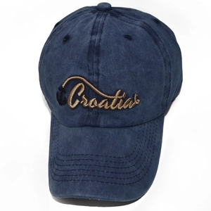 Detailansicht der goldenen Kroatien-Stickerei und des Ankers auf einer blauen Jeans-Cap