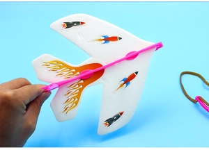 Detail of white foam glider toy with rocket stickers and pink catapult hook mechanism