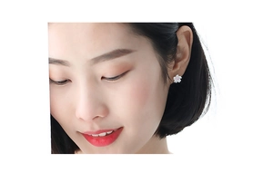 Close-up of pink cherry blossom earrings with silver petals on a female model's ear
