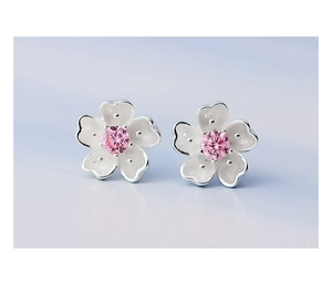 Macro shot of silver cherry blossom studs with pink zircon and white enamel petals