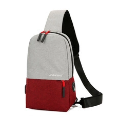 Detail of grey and red canvas chest bag with USB port and adjustable black shoulder strap