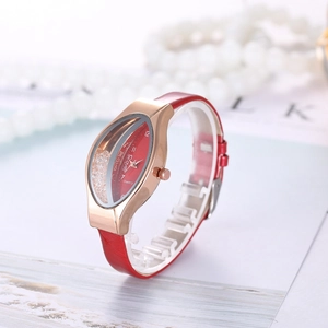 Detailed macro view of red quartz watch featuring a leaf-shaped case and floating crystals