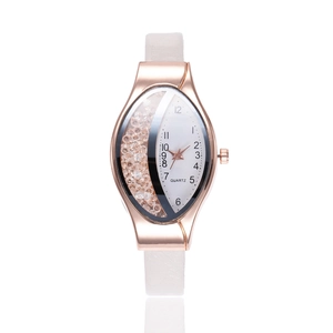 Detail of rose gold oval watch with floating crystals and white leather strap