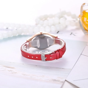 Detail view of red leather strap and rose gold case on creative quartz women watch