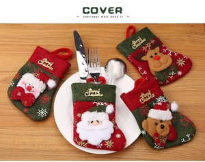 Christmas cutlery holders set with Santa and reindeer motifs on a wooden table setup