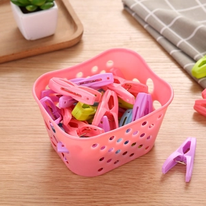 Windproof plastic laundry pegs set with a storage basket on a wooden table