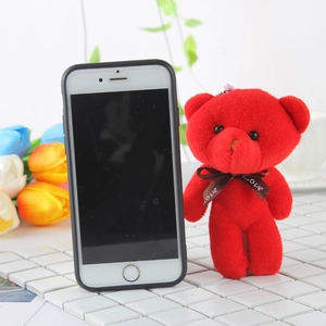 Red plush teddy bear keychain with Love ribbon shown next to a smartphone for size
