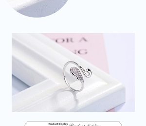 Detailed close-up of swan-shaped open ring with cubic zirconia stones on tiered display