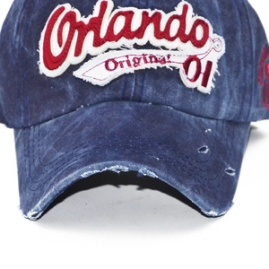 Close-up of vintage washed denim baseball cap with Orlando letter embroidery and distressed brim